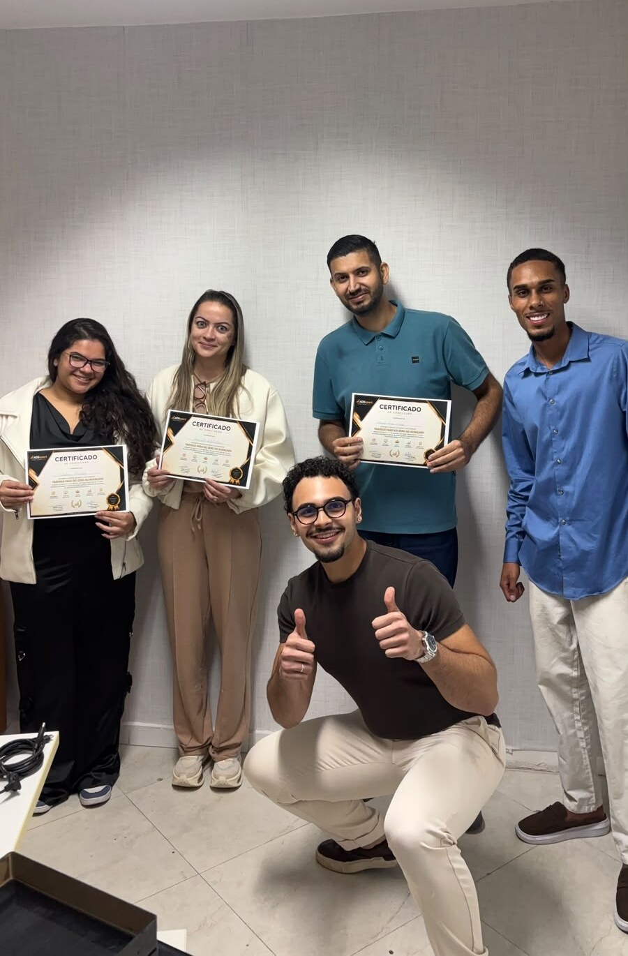 Alunos formados segurando os certificados da imersão de tráfego pago e inteligência artificial
